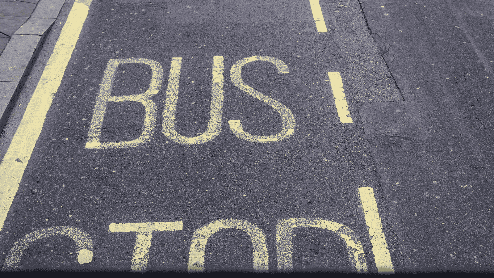 Yellow bus stop road marking on tarmac