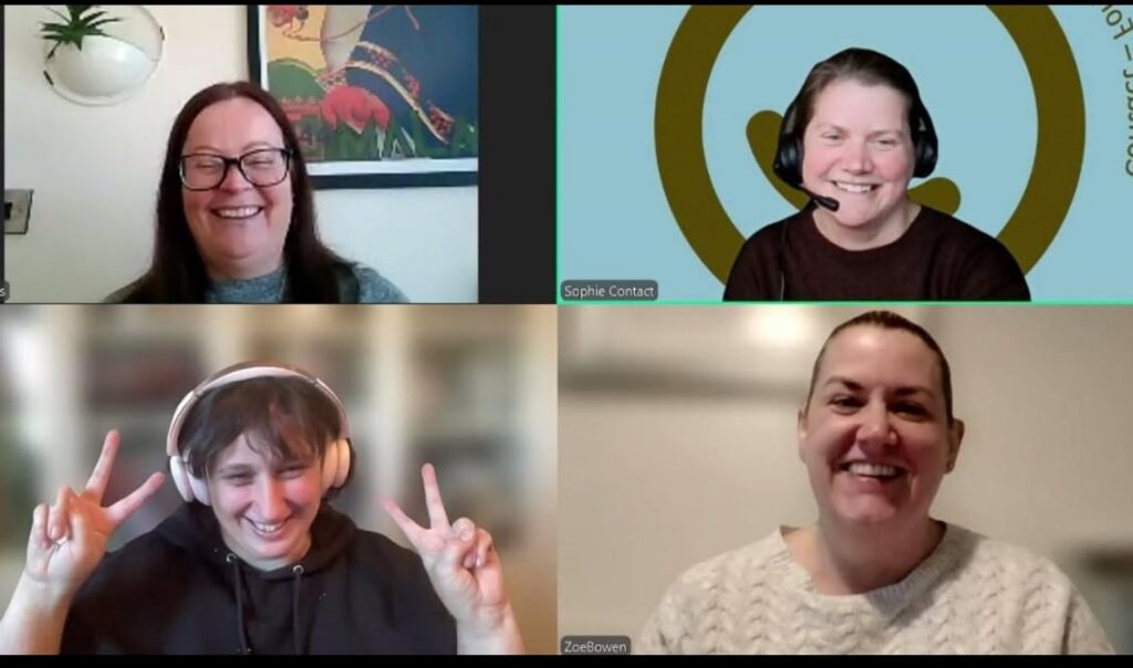 Four people smile during a video call. Three wear headphones, and one makes a peace sign with both hands. Each person is in a separate frame with different backgrounds.