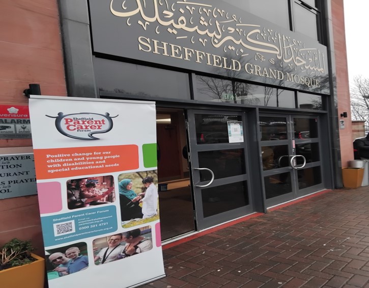 A banner for the Sheffield Parent Carer Forum standing outside the entrance to the Sheffield Grand Mosque.